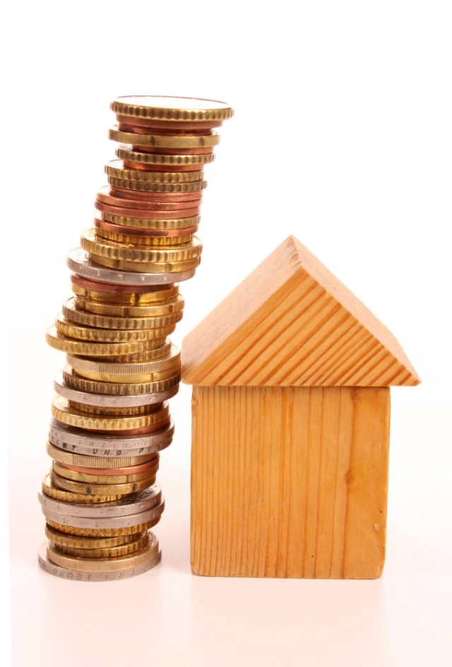 A wooden house next to a pile of coins